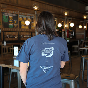 Someone wearing a Navy pigment dyed Comfort Colors tshirt with Moonlight Brewing and NPBC Triangle logo on the back.