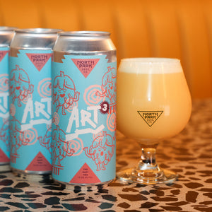Three cans of North Park Beer Co. Art³ with a glass of beer on a patterned surface.