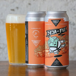 Two cans of 'DEJA-FU!' beer with a glass of beer on a wooden surface.