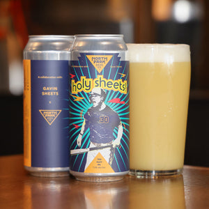 Two cans of Holy Sheets Metropolis Mashup next to glass of beer