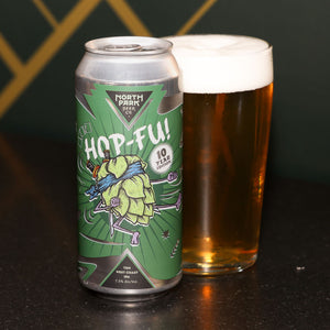 Can of North Park Beer Co. Hop-Fu! 10 Year Edition next to a glass of beer on a dark surface.