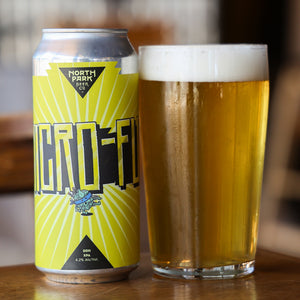 North Park Beer Co can of Micro-Fu! and glass of beer on a wooden surface