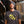 Load image into Gallery viewer, Someone wearing a charcoal gray t-shirt with yellow text and a beanie, standing in a brewery setting.
