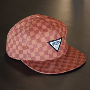 Rust and Dark Orange Checkerboard pattern woven hat with our triangle logo patch sewn on the front.