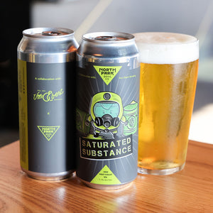 Two cans of Saturated Substance West Coast IPA next to glass of beer