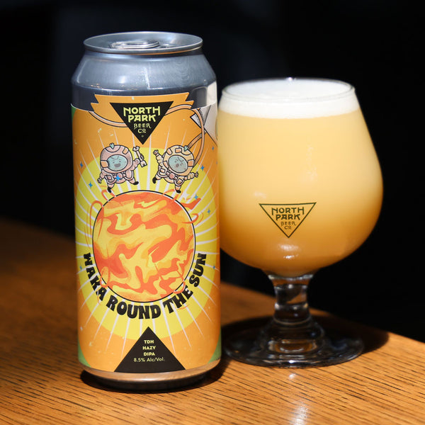 North Park Brewing can and glass of beer on a wooden surface with a dark background