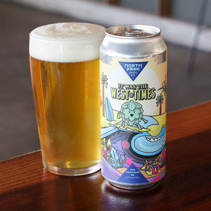 Can of It was the West of Times and glass of beer on a wooden surface