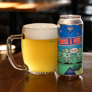 Glass mug of beer next to a can of 'North Park Brewing Co. Worth a Squiz on a wooden table.