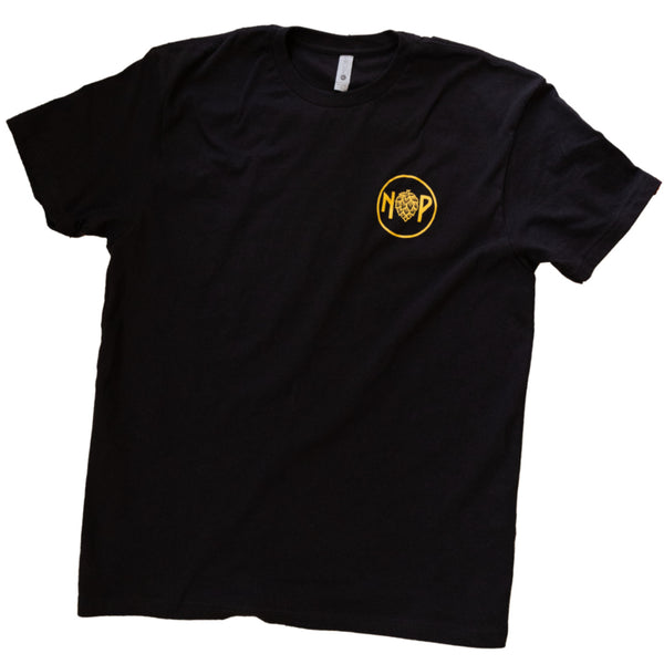 A black t-shirt featuring our circle NPBC logo in a golden tone on the front pocket area.